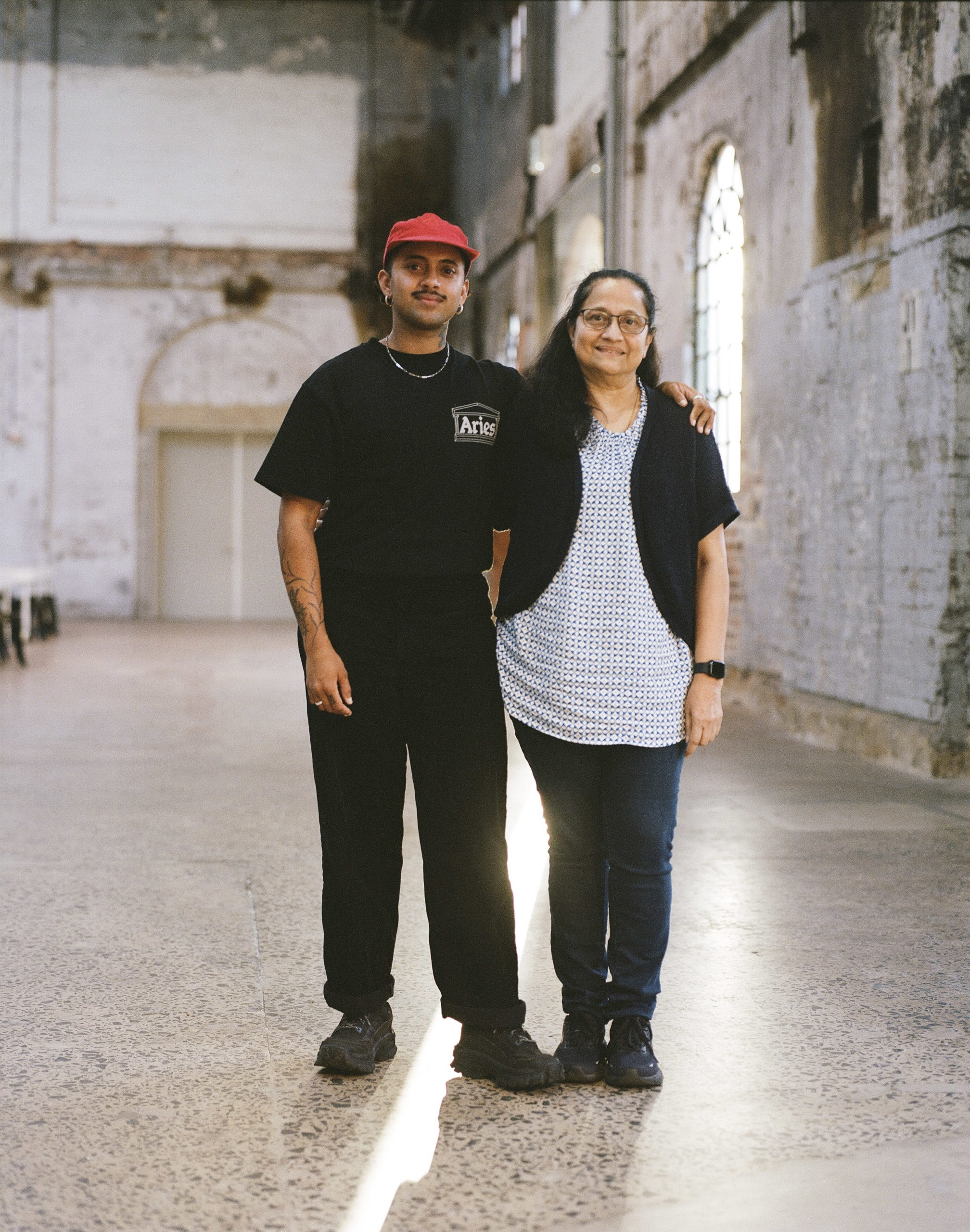 A photo of Krishna Istha and his mother Geetha, stood side by side in a large space.